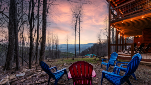 Colorful outdoor fire pit area chairs, overlooking a mountain view at sunset.