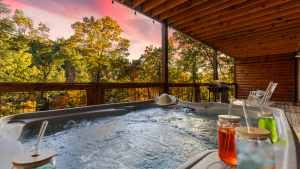 Private hot tub on a Gatlinburg cabin deck with scenic smoky mountain views at sunset