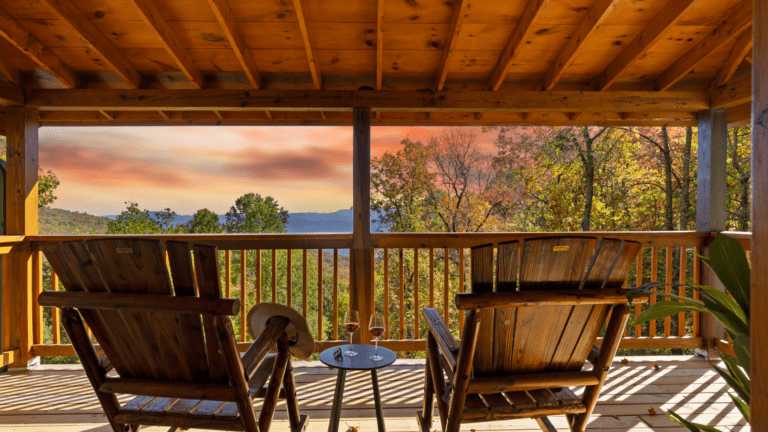 Cabin porch with rocking chairs and a sunset view.