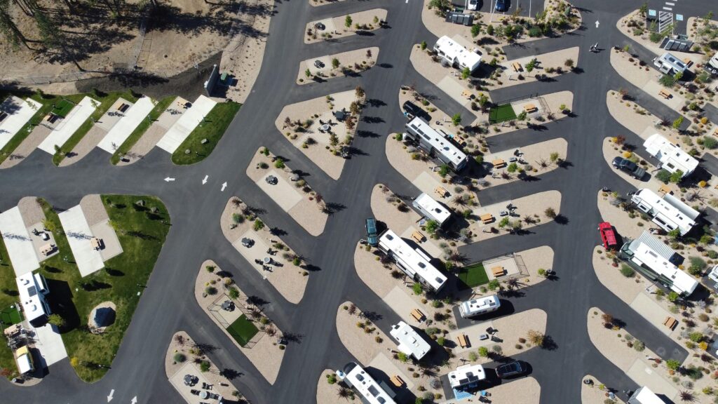 Aerial view of an RV park with rows of recreational vehicles on angled paved lots, surrounded by roads and landscaped areas&mdash;ideal for Gatlinburg TN camping and those seeking campgrounds near Gatlinburg.